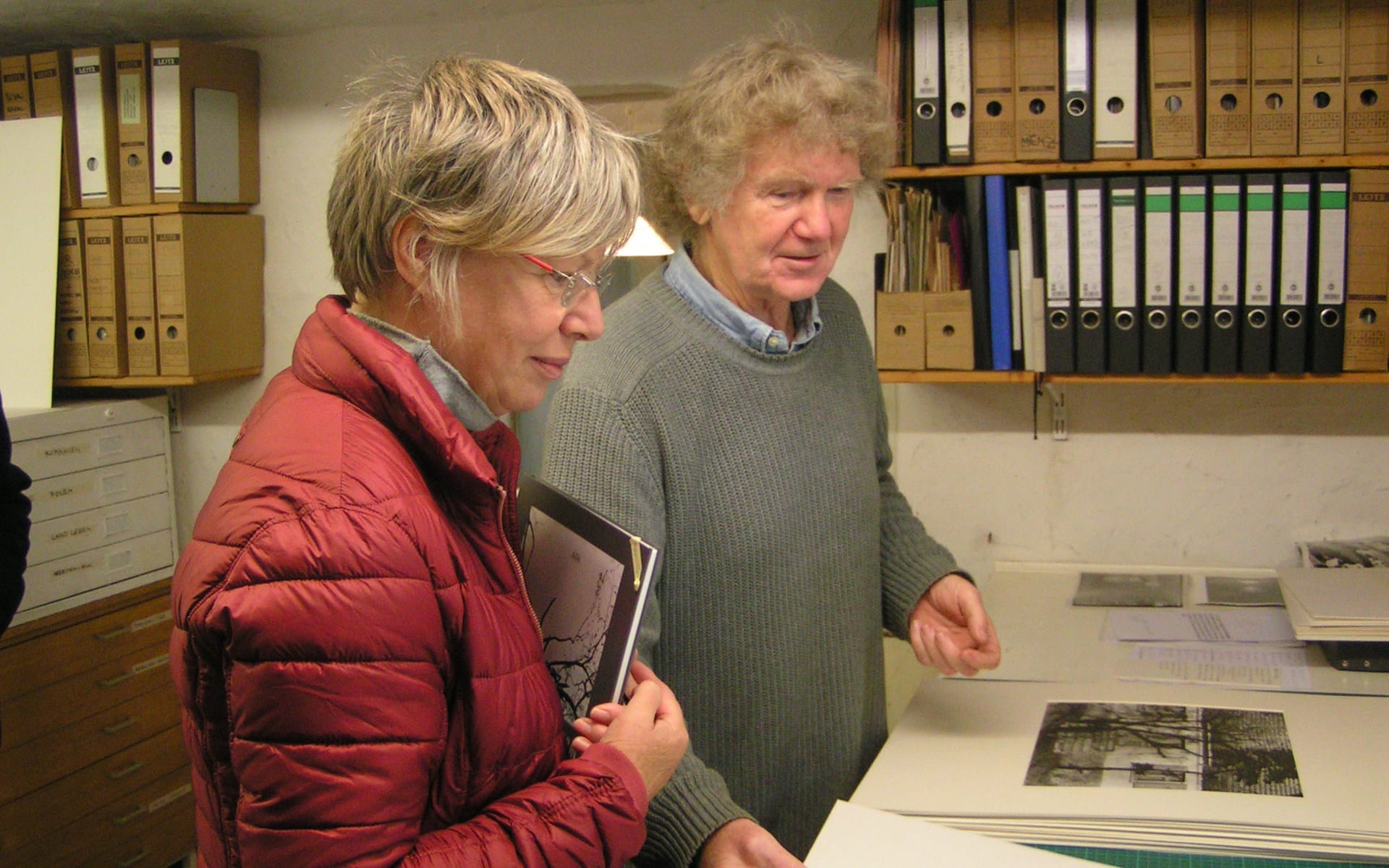 Kunsttour Stechlin - Jürgen Graetz im Atelier zeigt einem Gast seine Bilder