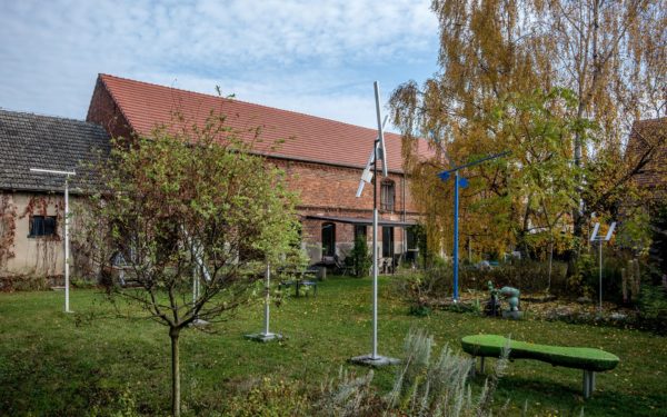 Kunsttour Betzin-Brunne - Die Skulpturen im Garten und Werkstatt im Hintergrund